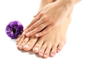 Female feet at spa pedicure procedure with flower isolated on wh