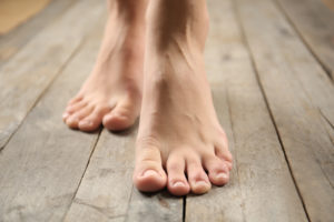 Female feet on wooden background